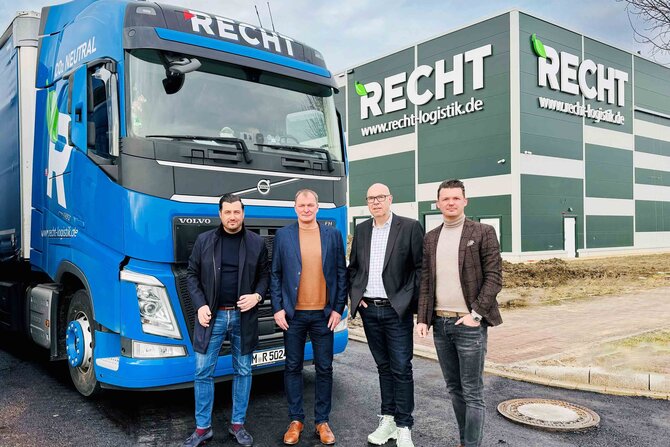 Gruppenbild vor einem Lkw und dem neuen Gebäude der RECHT Logistik Gruppe.